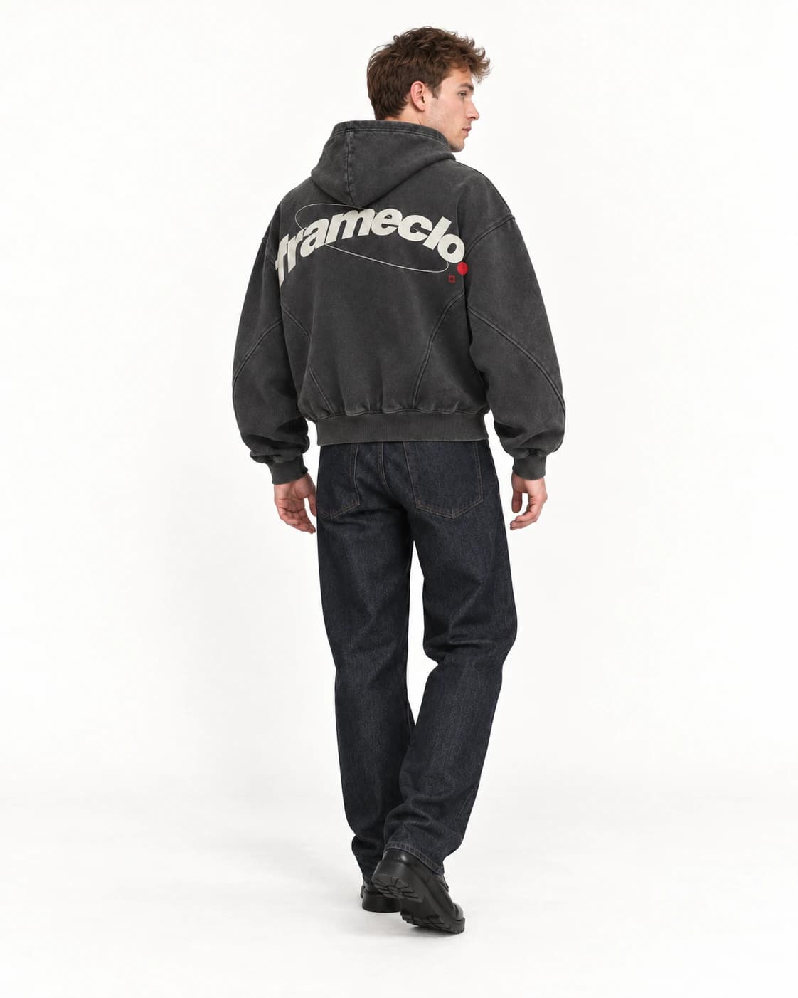Model turning while wearing the FrameClo hoodie in a white studio