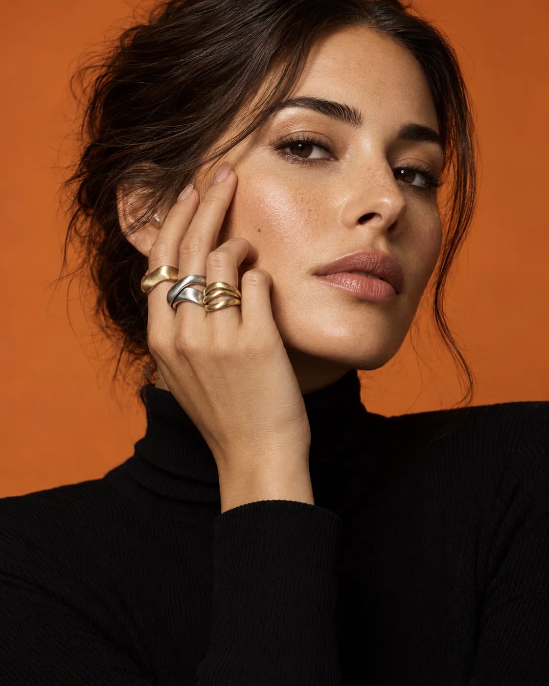 Editorial close-up of gold and silver rings on a model