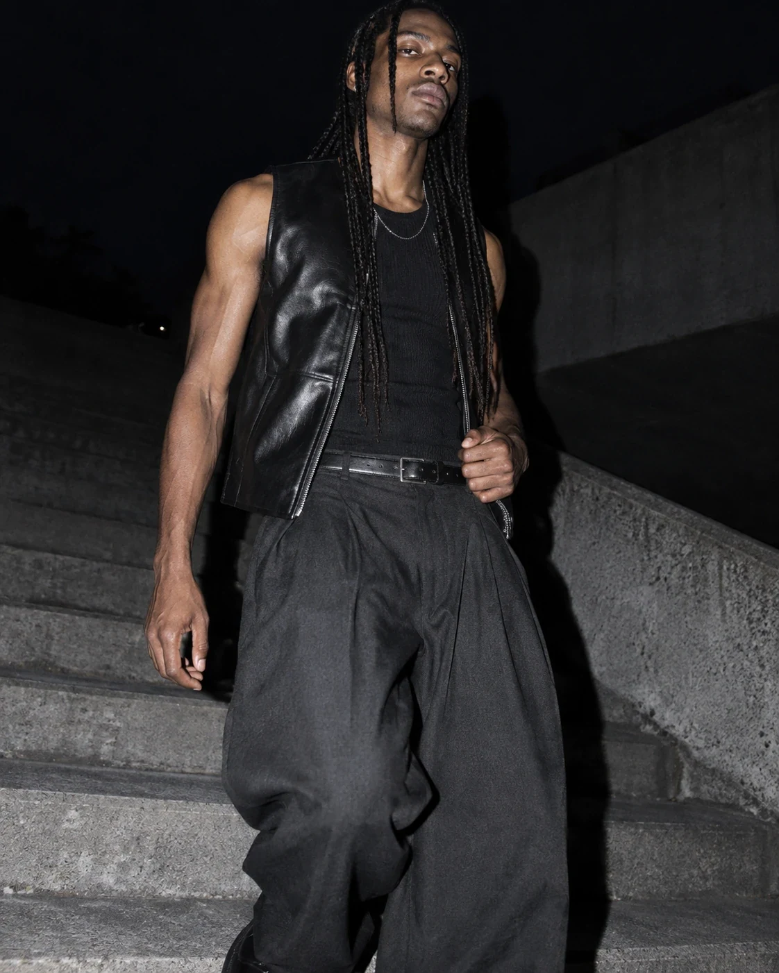 Model in leather and relaxed tailoring photographed with hard flash at night