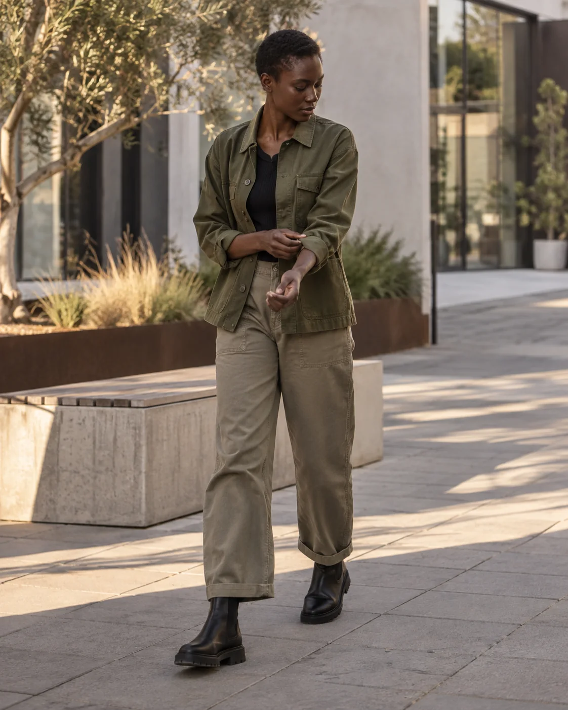 Model in olive workwear walking through a design district